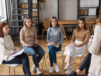 close-up-women-sitting-chairs